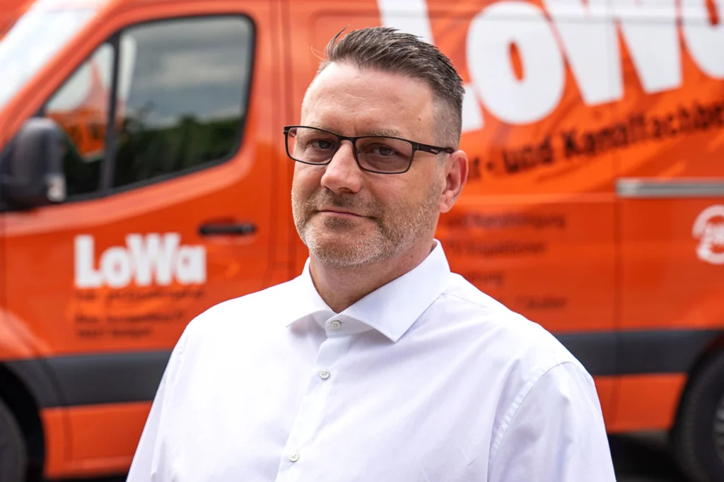 Porträt von Ansprechpartner bei LoWa vor Servicefahrzeug als Bild für persönlichen Kontakt und Beratung.